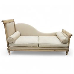 19th Century French day bed, the shaped back and scroll ends with fluted supports and carved rosettes, upholstered in natural linen with loose seat cushions and bolster pillows