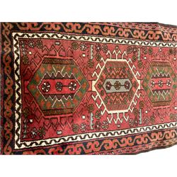 Persian red ground runner, the field decorated with seven stylised medallions, triple band border