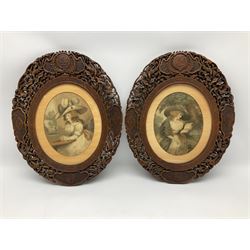 Pair of early 20th century carved and pierced Burmese hardwood frames, each of oval form carved with shaped panels, the uppermost detailed with initials, joined by flowering vines interspersed with birds, containing two coloured prints after George Morland 'Delia in Town', and 'Delia in the Country', overall H45cm W36.5cm apertures H27.5cm W22cm