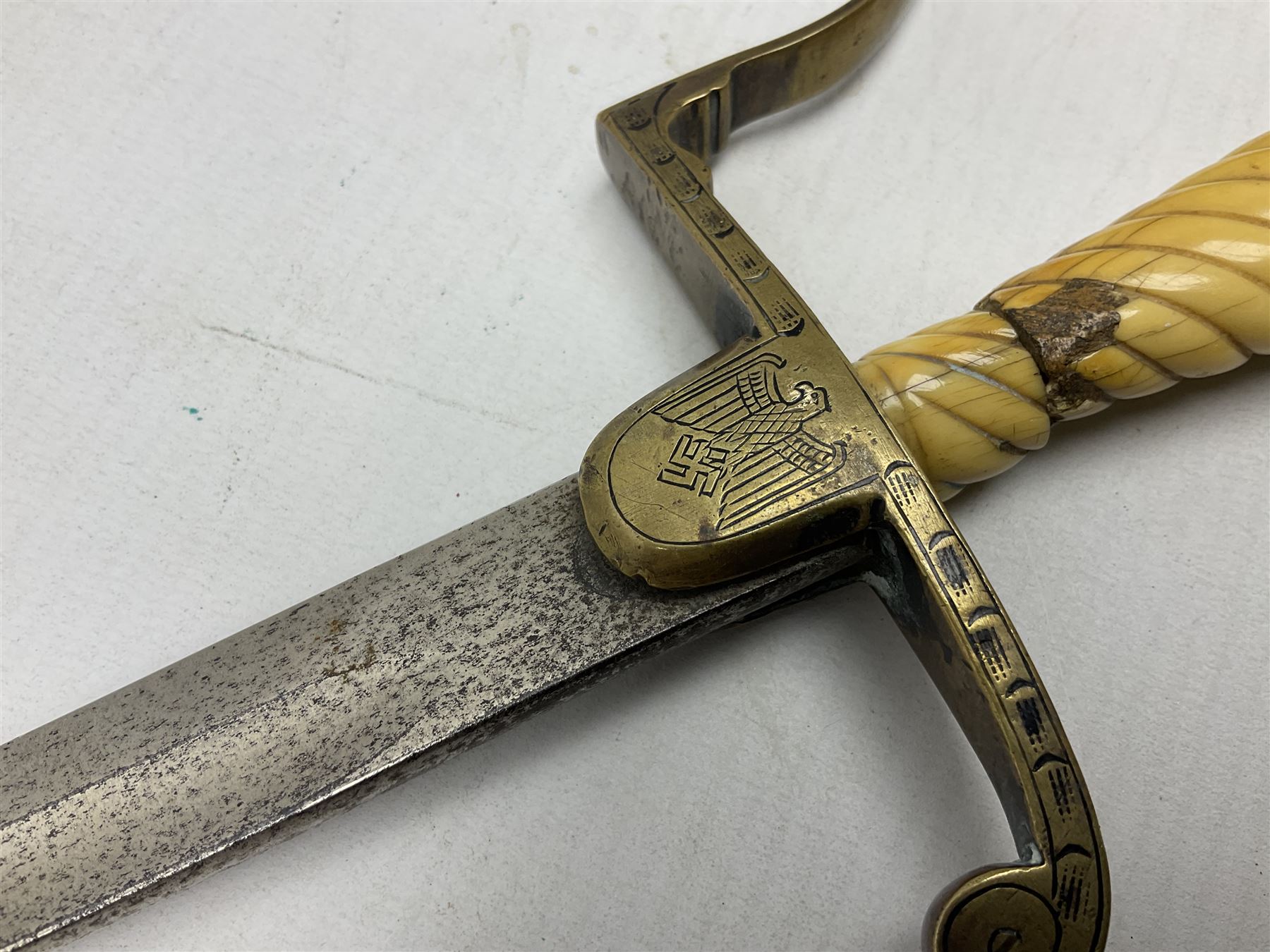 1900-1918 German Imperial NCO sabre with WW2 modifications of Wehrmacht insignia to the langet, 79cm slightly curving fullered blade and brass hilt, the knucklebow chased with oak leaves and acorns L90.5cm overall
This item has been registered for sale under Section 10 of the APHA Ivory Act 
