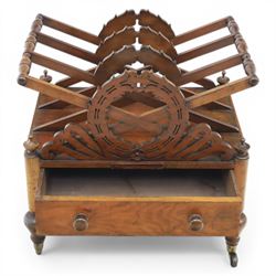 19th century mahogany music canterbury, with pierced dividers united by turned handles, above a single frieze drawer, raised upon baluster supports on brass castors