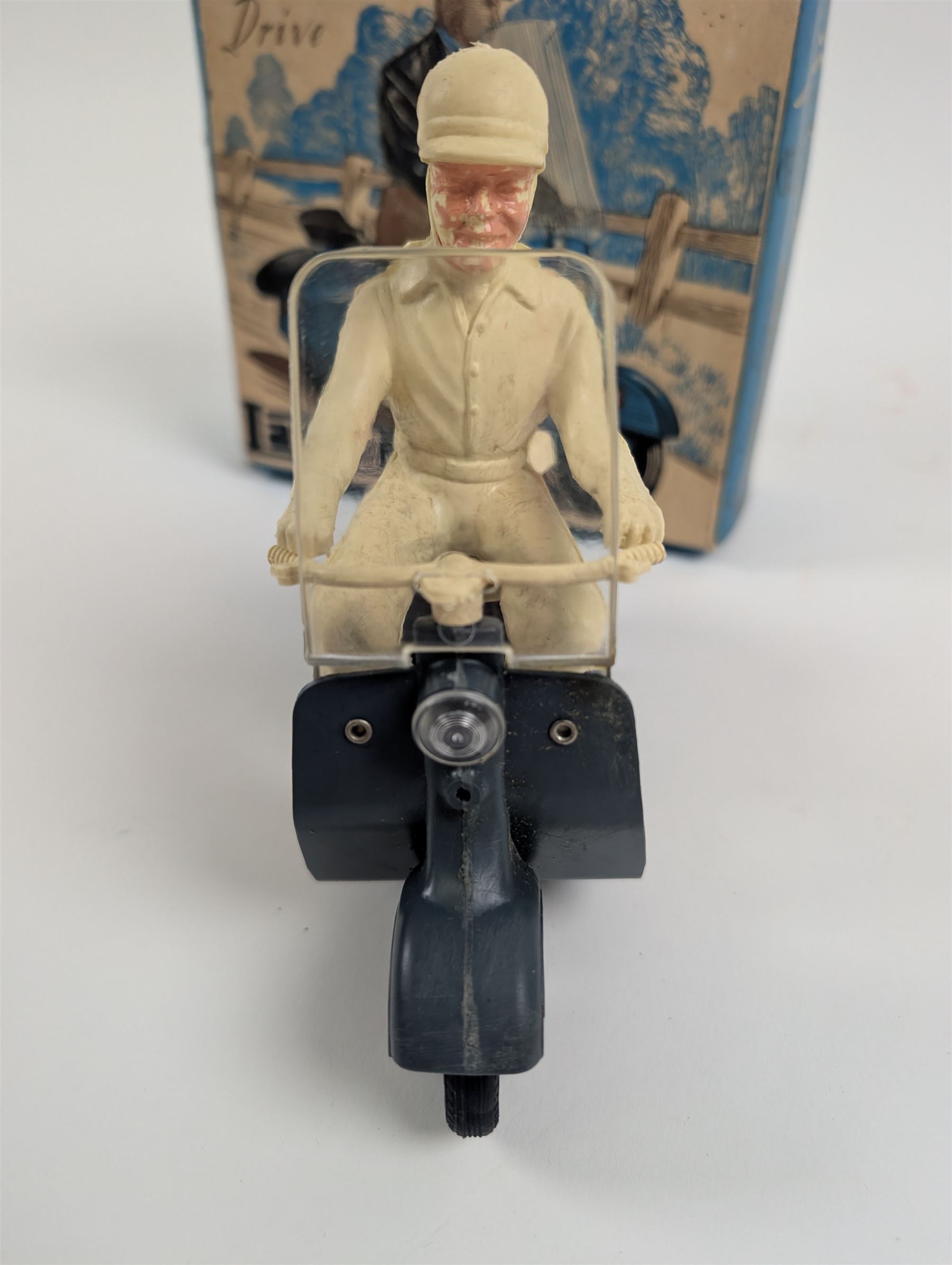 Mettoy friction drive Lambretta scooter no. 8134, the blue plastic scooter with cream handlebars and clear windshield, the rider with cream hat and clothing, stamped MTY 143 to front mud guards, in original box