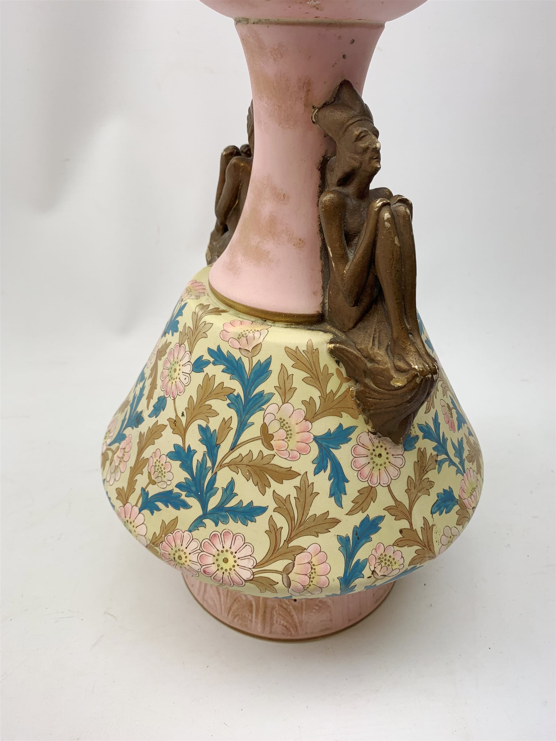 A late 19th century Aesthetic Movement Old Hall vase designed by Christopher Dresser, the flared body decorated with stylised flowering vines, leading to a tapering neck and flared rim with twin figural handles (one s/d), and raised upon a circular footed base, with printed mark beneath, H35cm. 