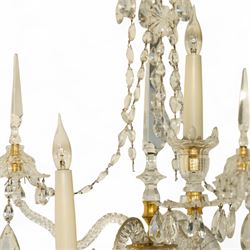 Pair of George III ormolu and cut-glass wall-lights, each with a tall central urn-shaped finial above a series of faceted glass spires and scrolled branches, the ormolu-mounted nozzles and drip pans hung with festoons of cut-glass drops and pear-shaped pendants, the lower section centred by a pineapple finial, wired for electricity
