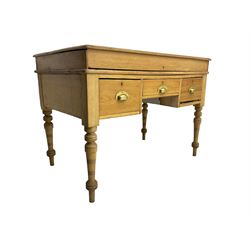 Early 20th century light oak kneehole desk, rectangular hinged top, fitted with frieze drawer flanked by two deep drawers, raised on ring turned supports