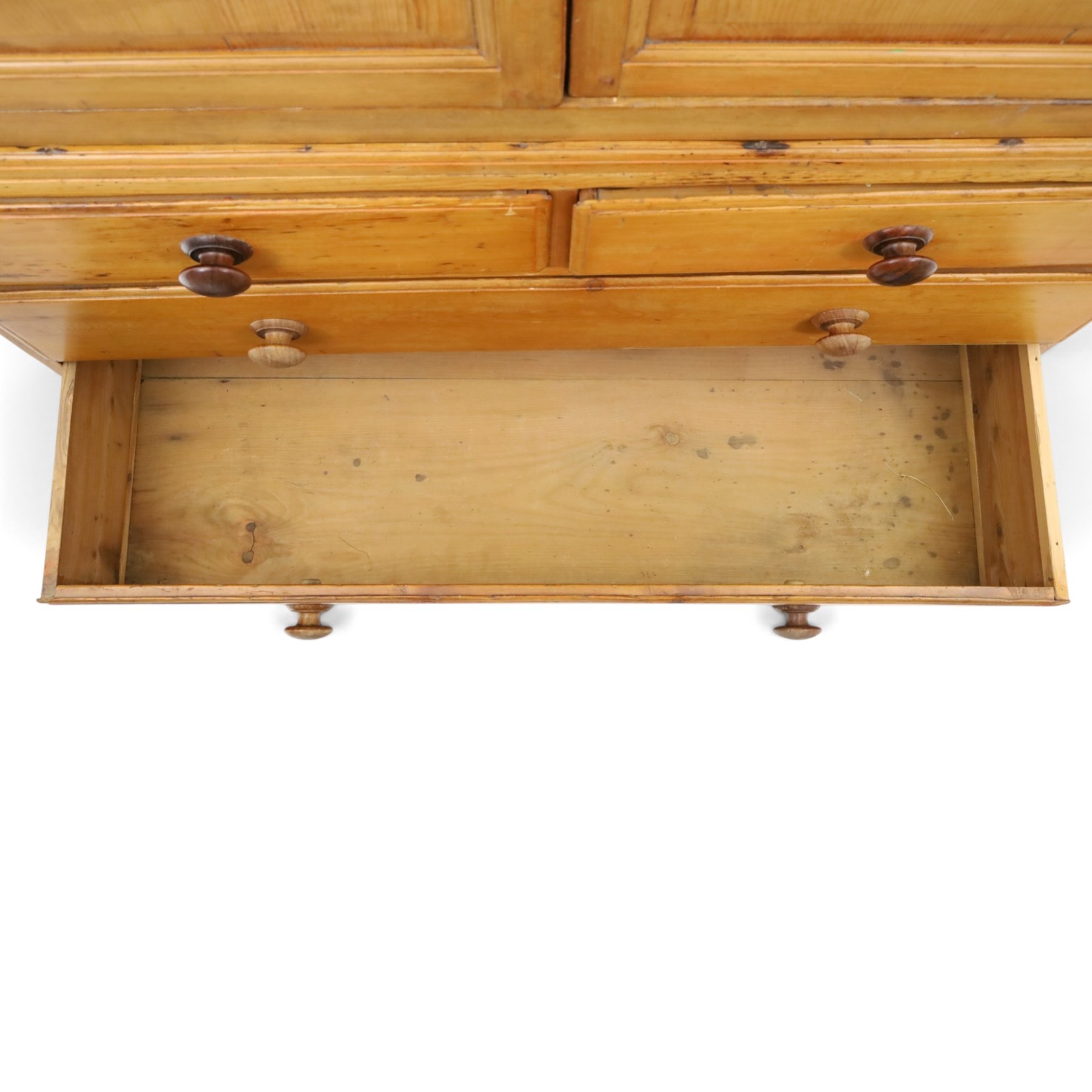 19th century waxed pine press cupboard, shaped cornice above a twin fielded panelled cupboard door enclosing a fixed shelf, the lower section two short two long drawer