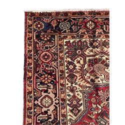 Persian Heriz red ground rug, large medallion decorated with palmettes and Ejder motifs, the border decorated with stylised plant motifs, within floral design guard stripes 