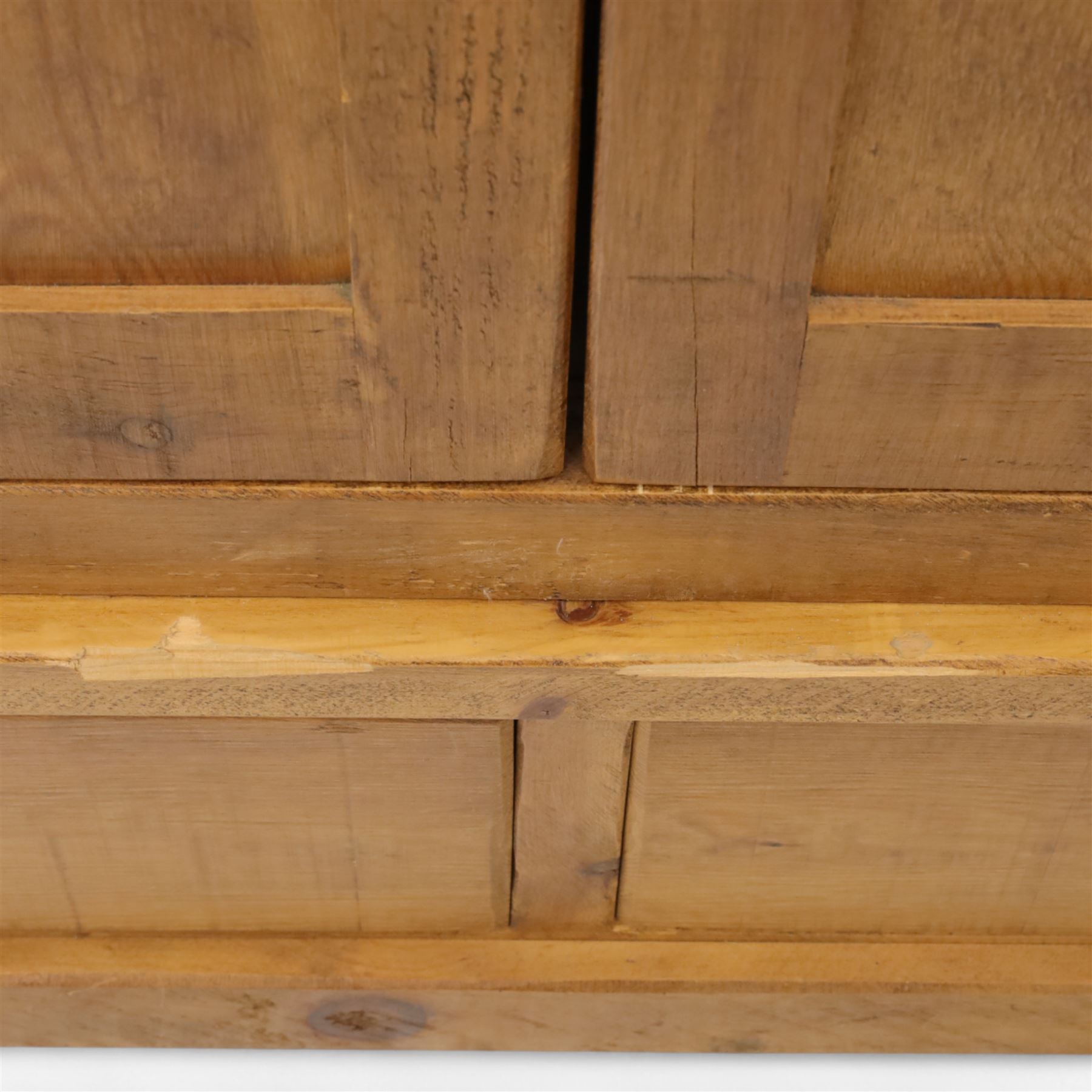 Contemporary pine hanging wardrobe, twin panelled doors enclosing open hanging space with brass rail, two drawers to lower section, on moulded plinth base
