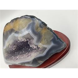 Amethyst crystal geode cluster, with well-defined crystals of various sizes, upon a carved wooden stand, H12cm, L20cm