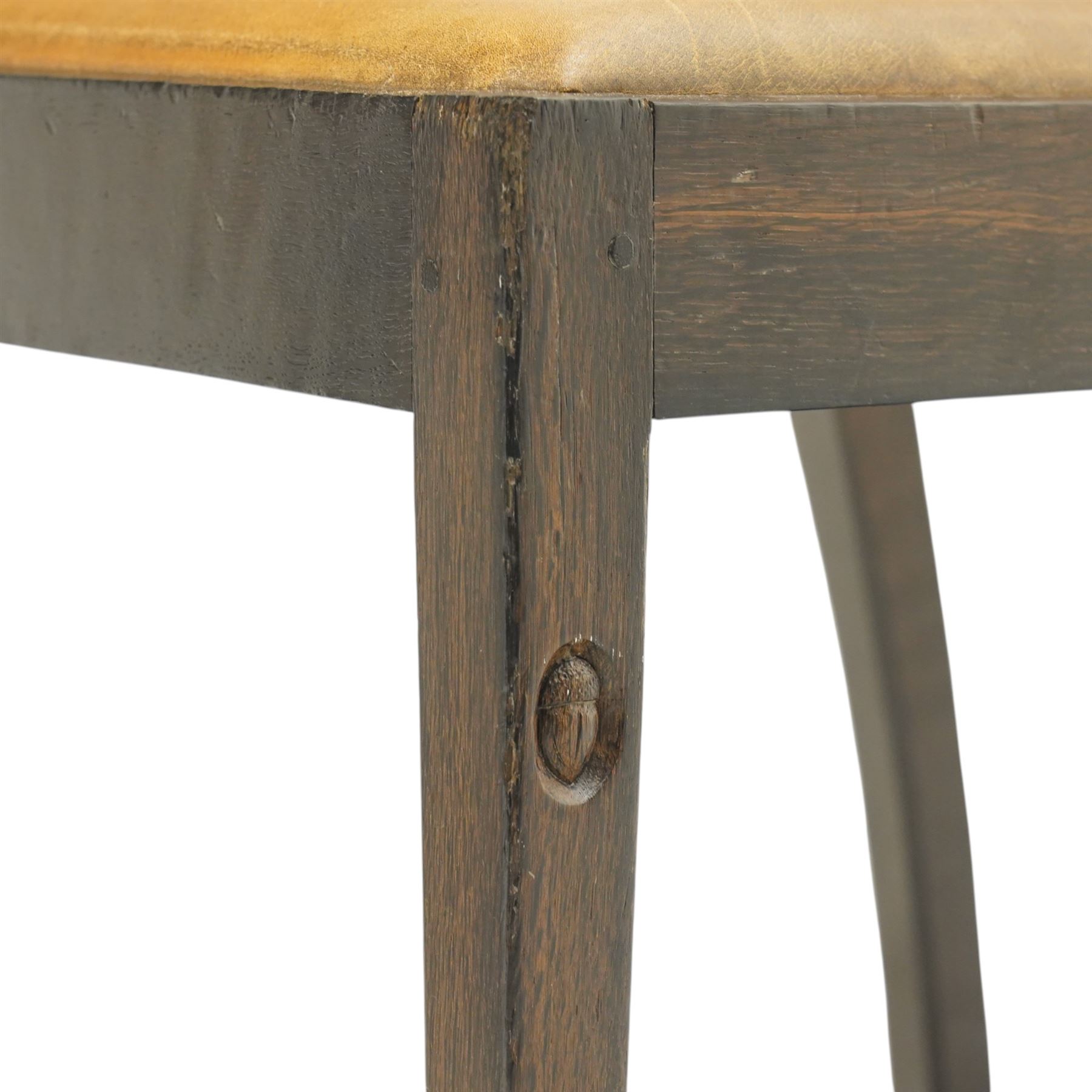 Acornman - set of four dark stained oak dining chairs, with four vertical slats, drop-in tan leather seat, supported on square tapering legs with carved acorn signature, by the workshop of Alan Grainger of Brandsby