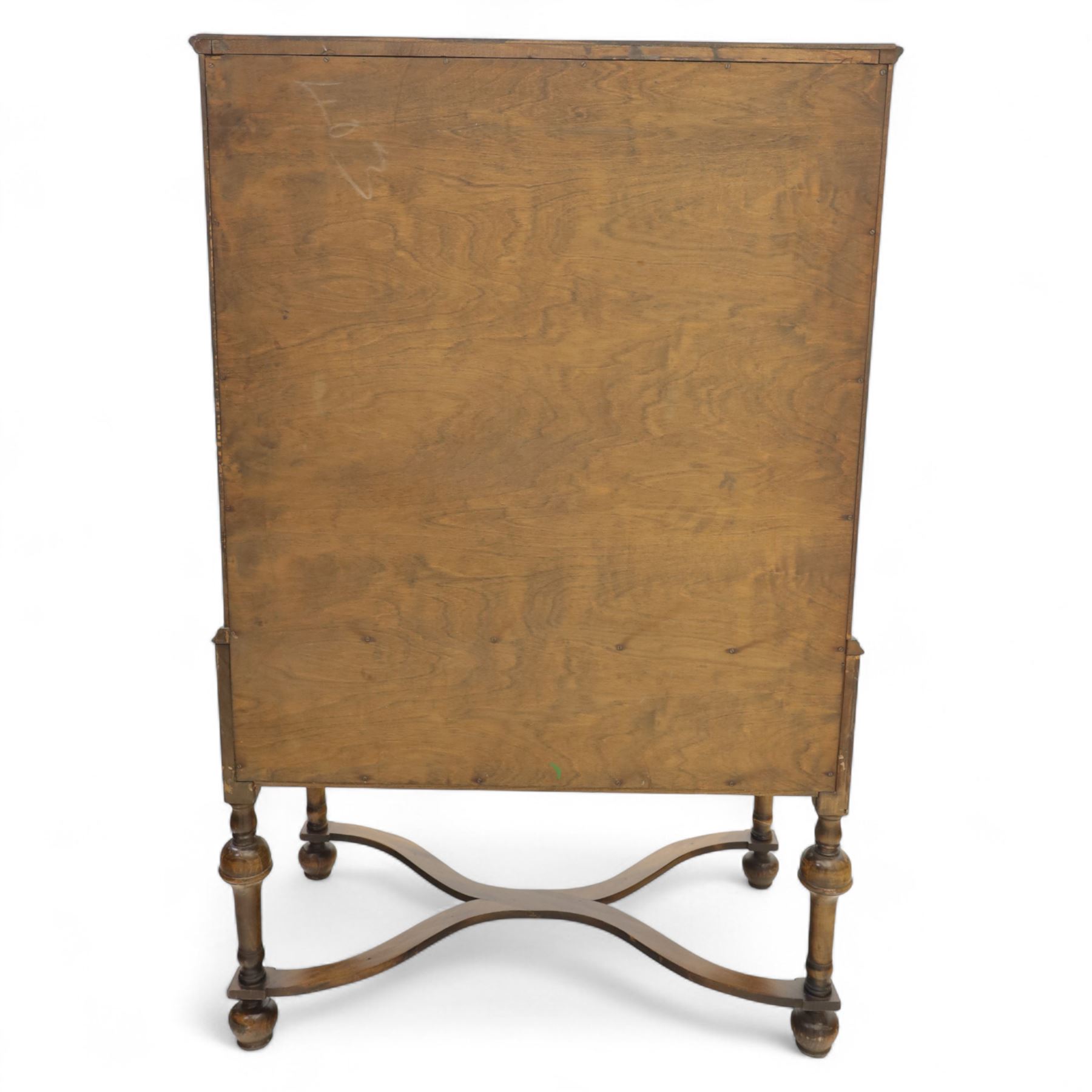 Georgian style walnut chest on stand, the figured top section fitted with four long drawers above a further drawer on the base, brass swan-neck handles, on turned legs joined by shaped stretchers with bun feet