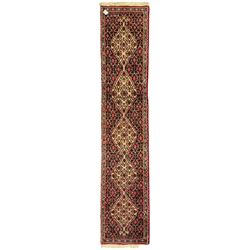 North West Persian Senneh indigo and crimson ground runner, the Herati decorated field with five interconnected lozenges, triple band border with repeating flower head motifs 
