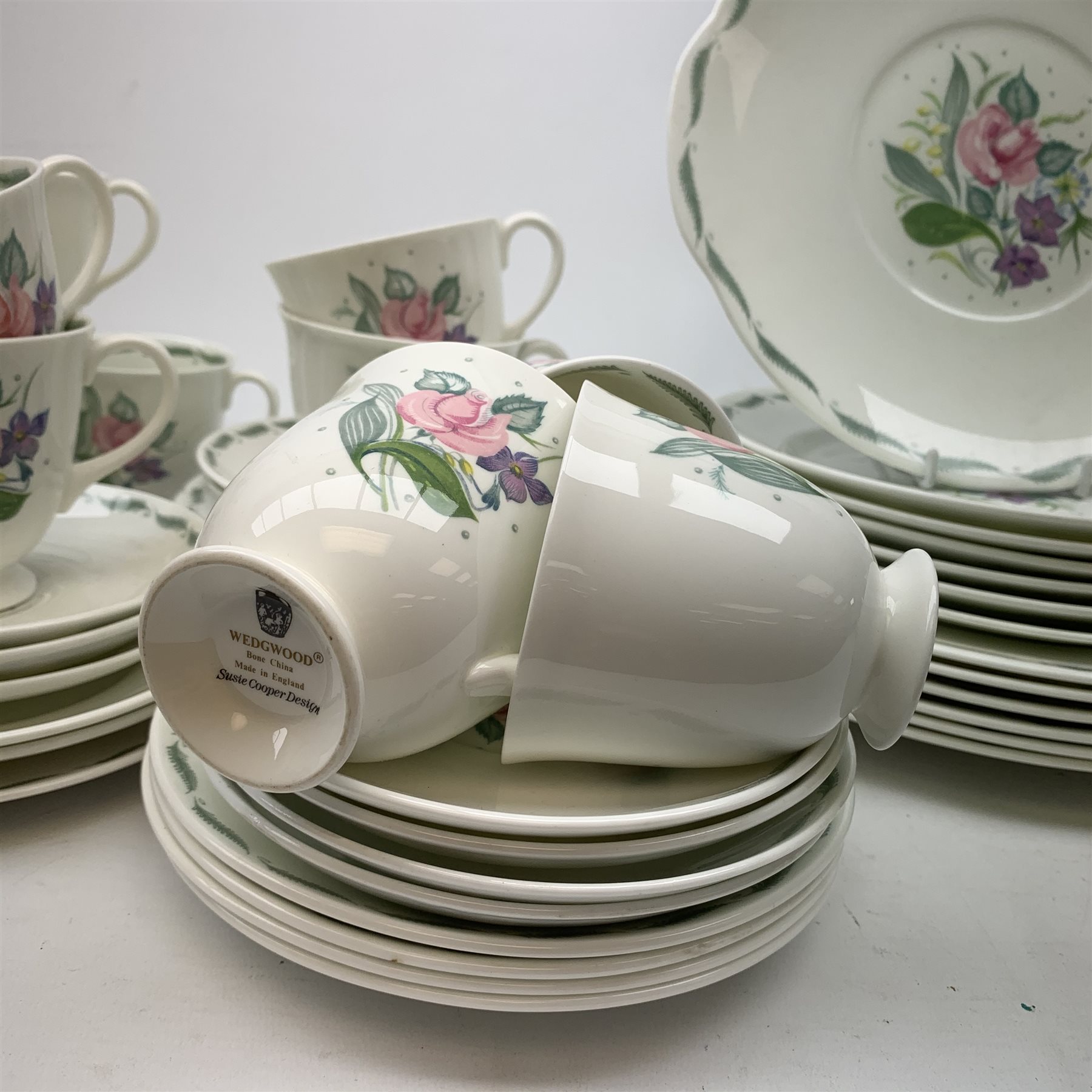 A Susie Cooper for Wedgwood Fragrance pattern tea service, comprising teapot, milk jug, open sucrier, fix teacups, five smaller teacups, five saucers, four further saucers, six side plates, five side plates with frilled rim, a slightly larger side plate, six dessert plates, six larger plates, six bowls, and a sandwich plate. 