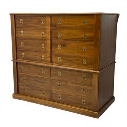 Walnut two sectional military style chest cabinet, the top section enclosed by two hinged and retractable doors, the lower section fitted with six drawers, with Wellington style hinged stays, on plinth base