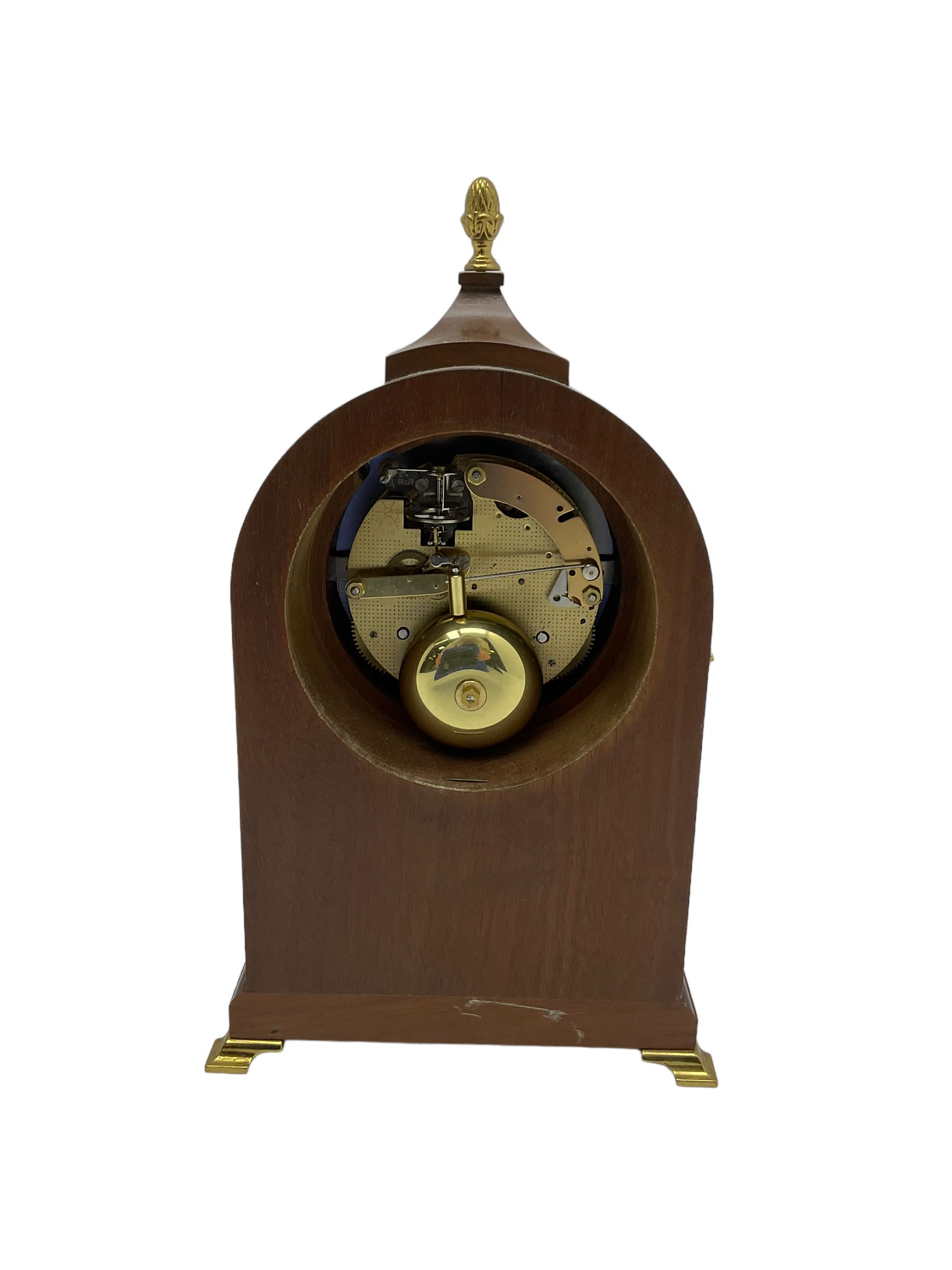 Comitti of London - 20th century 8-day mantle clock, in classic round topped mahogany case with inlaid stringing to the front and lion mask handles to the sides, raised on a narrow plinth with bracket feet, twin train going barrel movement with a floating balance escapement, striking the hours and half hours on a bell.    