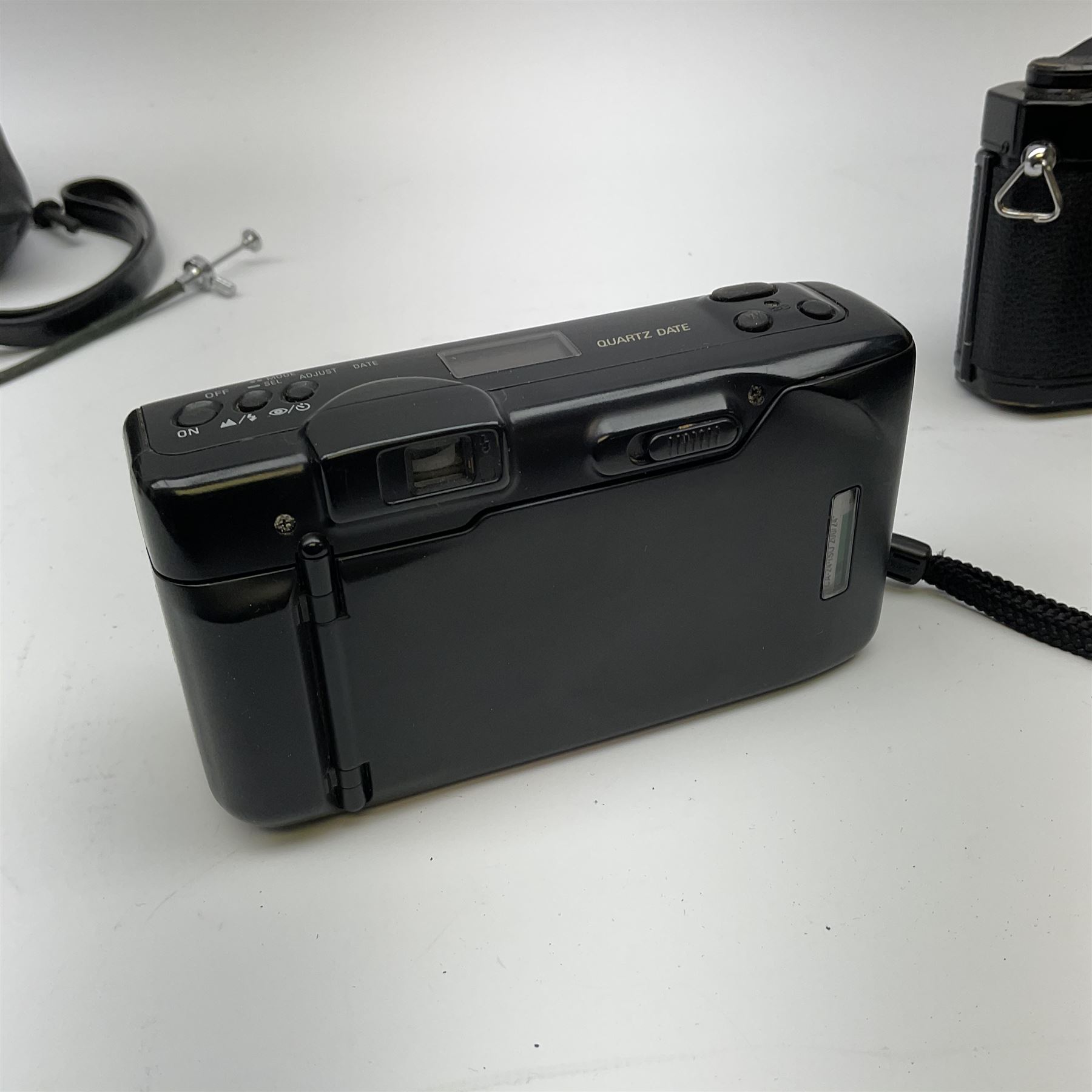 Nikon FM 35mm SLR camera body, Sigma 28-300mm 1:3.5-6.3 lens, Cosina 100mm 1:3.5 macro lens, two macro adaptors, instruction manual, Nikon 'Lite-Touch zoom' 35mm camera, and three relating carrying cases