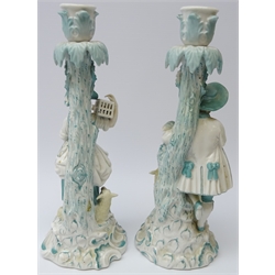  Pair 19th century porcelain candlesticks modelled as a male and female leaning against a tree amongst animals, possibly Milan San Cristoforo, H27cm   