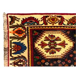 South West Persian Qashqai red ground runner, the crimson field decorated with three connected lozenges, surrounded by small stylised motifs of bird and plants, indigo spandrels with further stylised motifs, the border with repeating floral design 