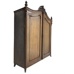 Early 20th century Italian walnut armoire wardrobe, the pierced and scrolling pediment carved with acanthus leaf detail, flanked by two scrolling cartouche with matching corbels below, the two panelled doors with applied carved rinceaux slips, with a central spiral turned upright, enclosing single shelf and hooks, raised on scroll feet