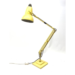 A yellow Herbert Terry & Sons Ltd Anglepoise lamp, on a square stepped base. 
