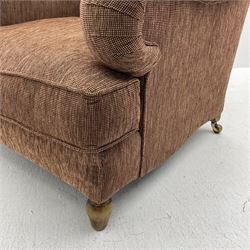 Howard style club armchair, upholstered in maroon and beige ribbed fabric with loose seat cushion, turned front feet and splayed rear feet fitted with brass castors