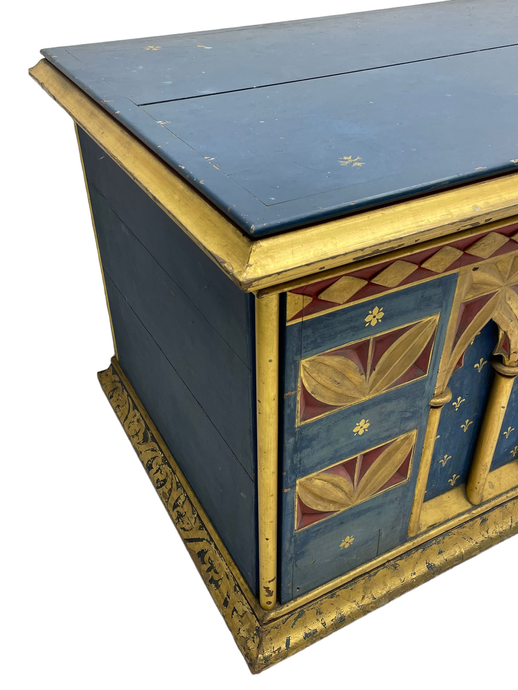 In the manner of William Burges - mid-to-late 19th century English Gothic Revival pine altar or console table, in blue and red paint with water gilding, the moulded rectangular top over six pointed arches with turned column supports, the front carved with a single row of lozenges and incised stylised motifs