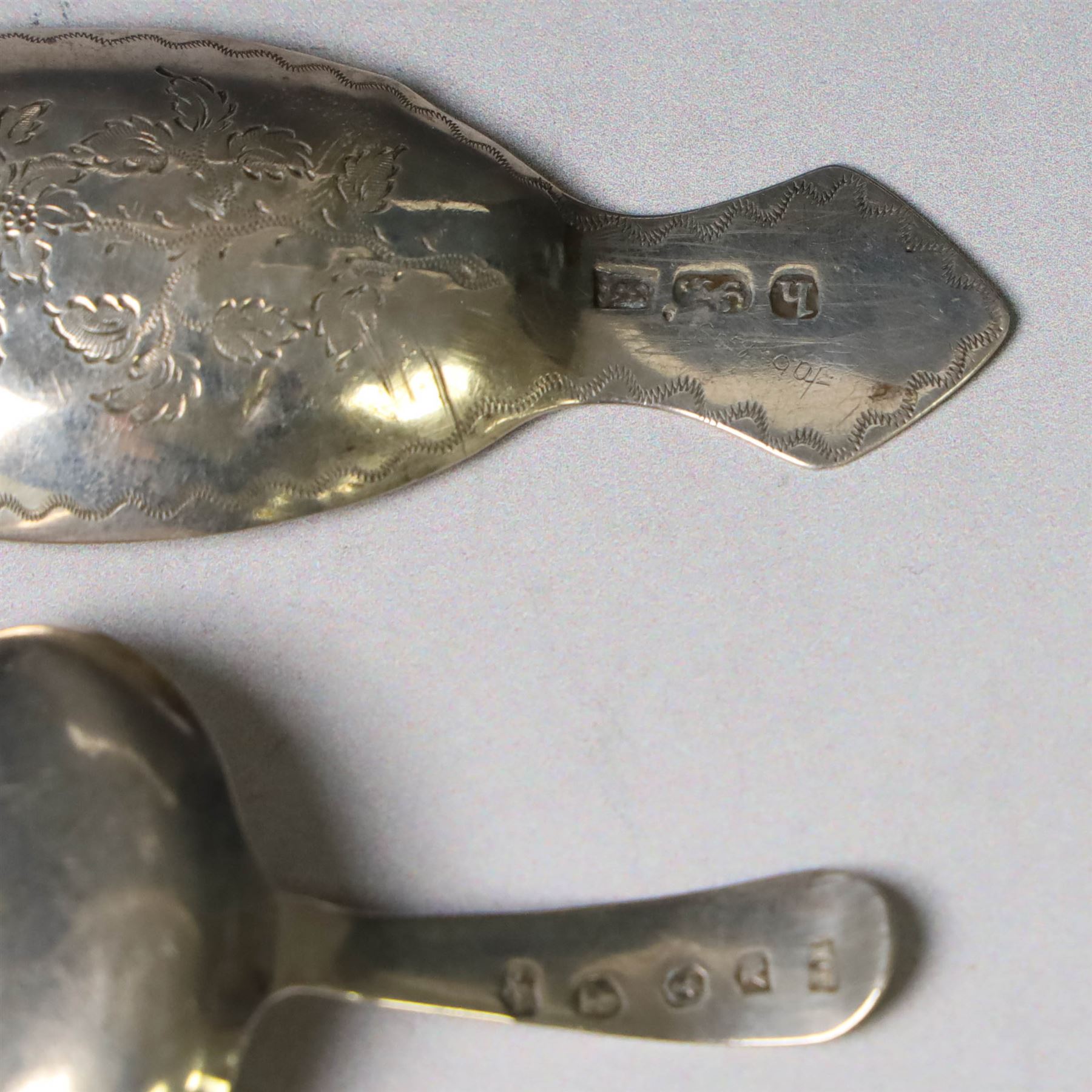 Two George III silver caddy spoons, the first example with oval bowl and flat handle with engraved initial, hallmarked Birmingham 1796, makers mark probably IT, the second with oval bowl, curved handle with shield and initial engraving, hallmarked George Smith III, London 1783