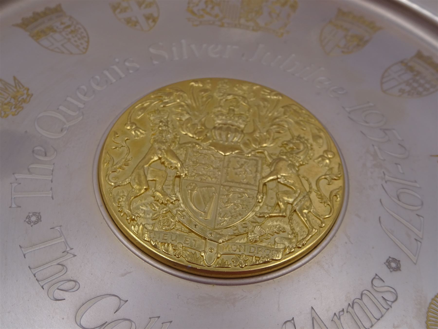 Modern limited edition silver The College of Arms plate to commemorate the The Queen's Silver Jubilee, the plain circular plate with central 24ct gold plated plaque depicting the Royal Arms, bordered by engravings of The College of Arms and the Kings Arms etc, by Danbury Mint, hallmarked Yorkshire Mint, Birmingham 1977, number 350/2500, in original fitted box with paperwork, D26,5cm, 