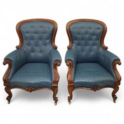 Fine pair of mid-19th-century mahogany library armchairs, carved frame with balloon-shaped back with scrolled ends, rolled wide arms, ending in a scrolled volute above a serpentine seat rail, upholstered in mottled turquoise faux leather, button upholstered back, arms, and cushion seat, studded sides and apron, raised on scroll carved front feet and splayed rear legs on castors 