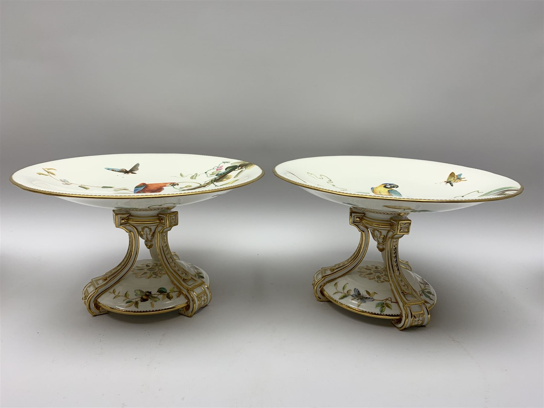 19th century Minton dessert service, comprising four comports, one tazza, and twelve plates, each hand painted with birds perched upon branches, and further detailed with insects and heightened in gilt, with printed retailers mark beneath for John Mortlock Oxford Street London, and impressed Minton mark to most, comport H13.5cm, plates D23.5cm. 
