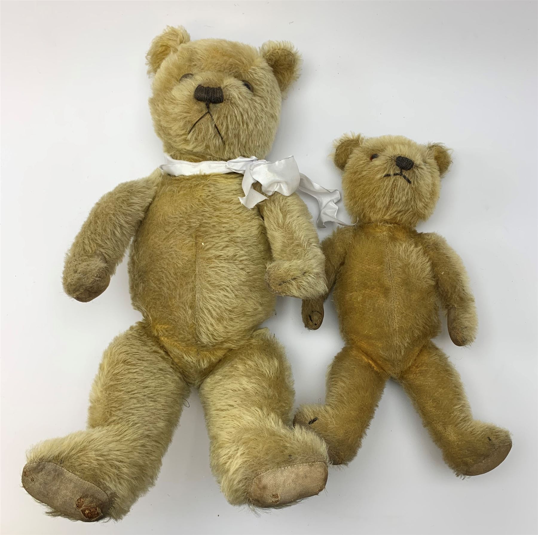 Two 1930s Chiltern type graduated teddy bears, one wood wool and one wood wool and kapok filled plush bodies, each with swivel revolving head, applied eyes and vertically stitched nose and mouth and jointed limbs, tallest H20.5