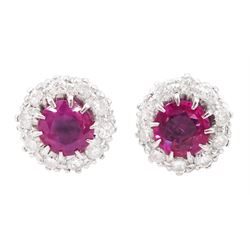 Pair of platinum and white gold round cut ruby and round cut diamond cluster stud earrings...