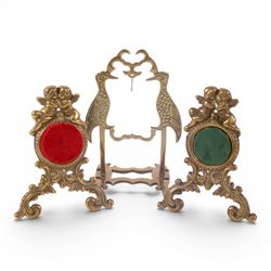 Collection of brass watch stands, including an example modelled as a cherub upon an onyx base, tallest H17cm  