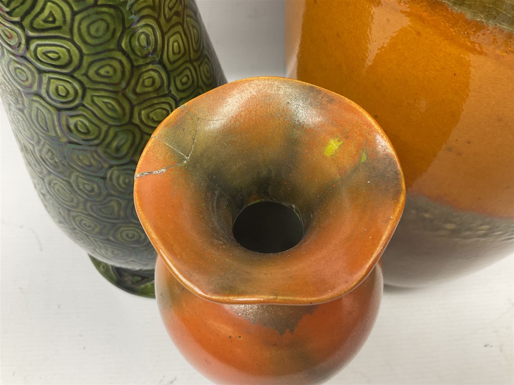 Burmantofts Faience vase, with elongated neck, and concentric circle decoration, in a green lustre glaze, together with a Bretby figure, modelled as a cat with a ball of wool, a Bretby vase, with fluted rim, in orange/red glaze, frog jug and a large West German vase, tallest H38cm