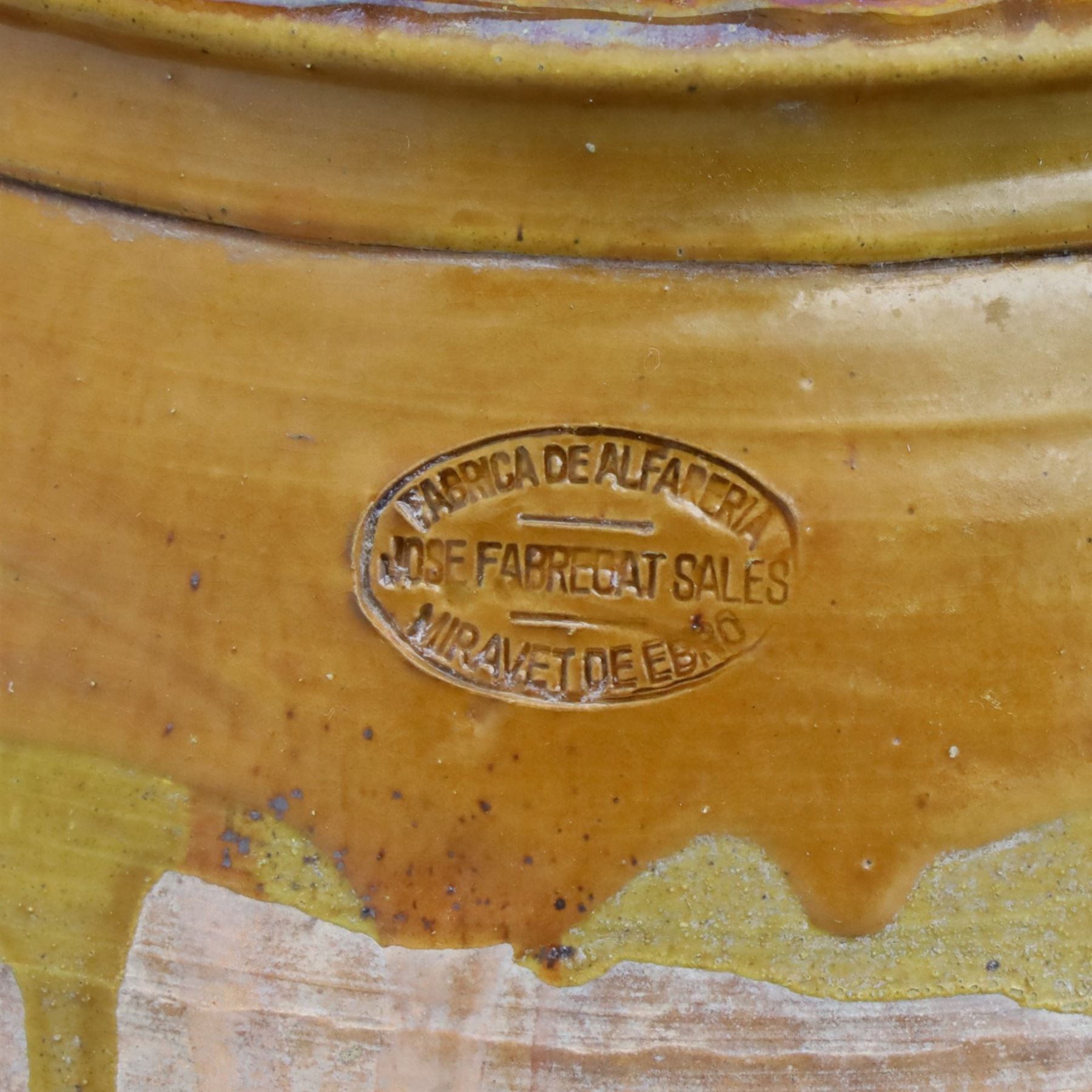 Large Spanish terracotta olive jar, of typical baluster form with drip glaze decoration and three lug handles, with impressed mark fabrica de alfareria, H58cm