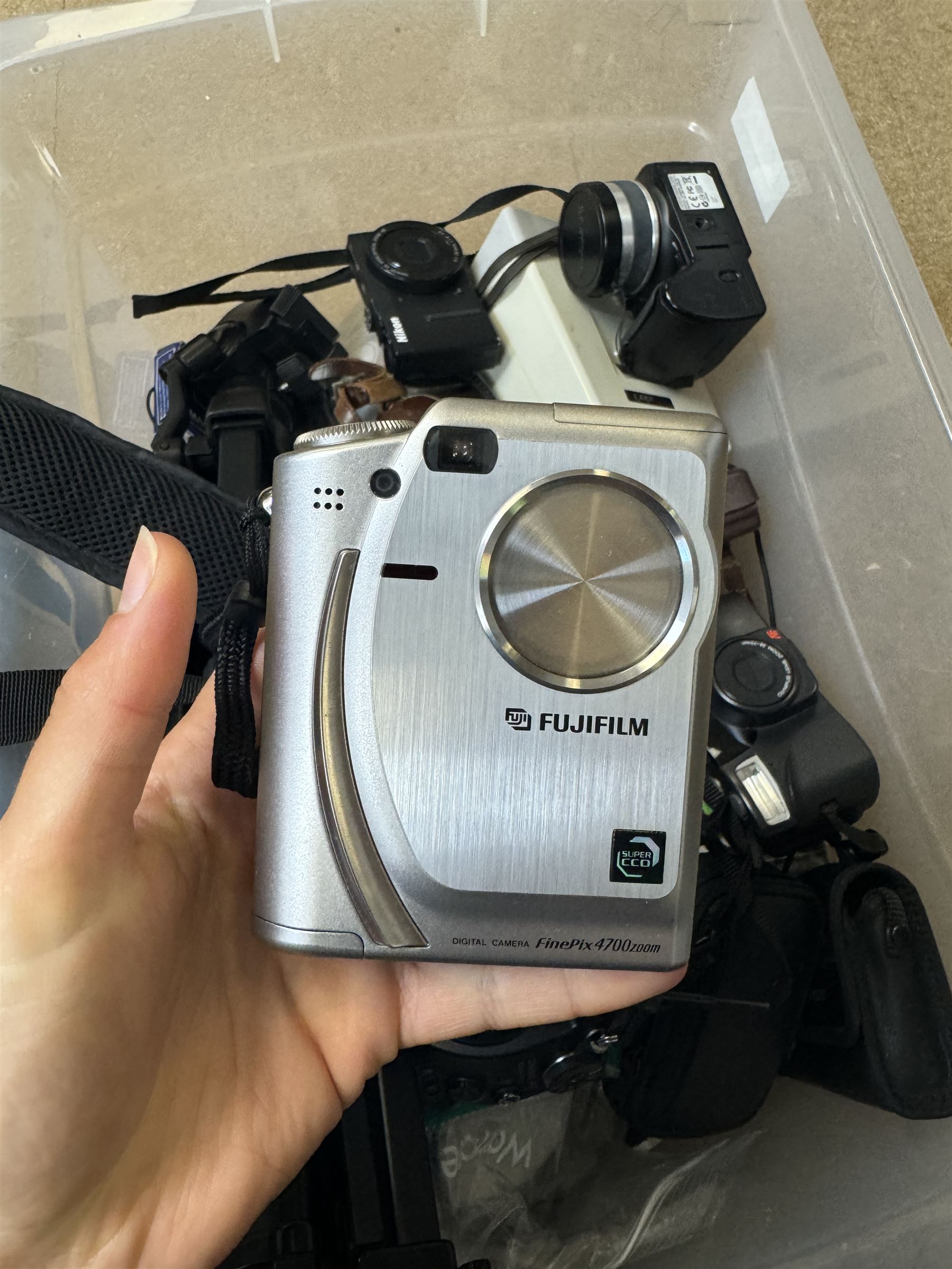 Collection of cameras and camera equipment, including Voigtlander Vitomatic I, Nikon Coolpix P340, Nikon Coolpix S9100, Olympus SP-510UZ, tripod, cases, etc