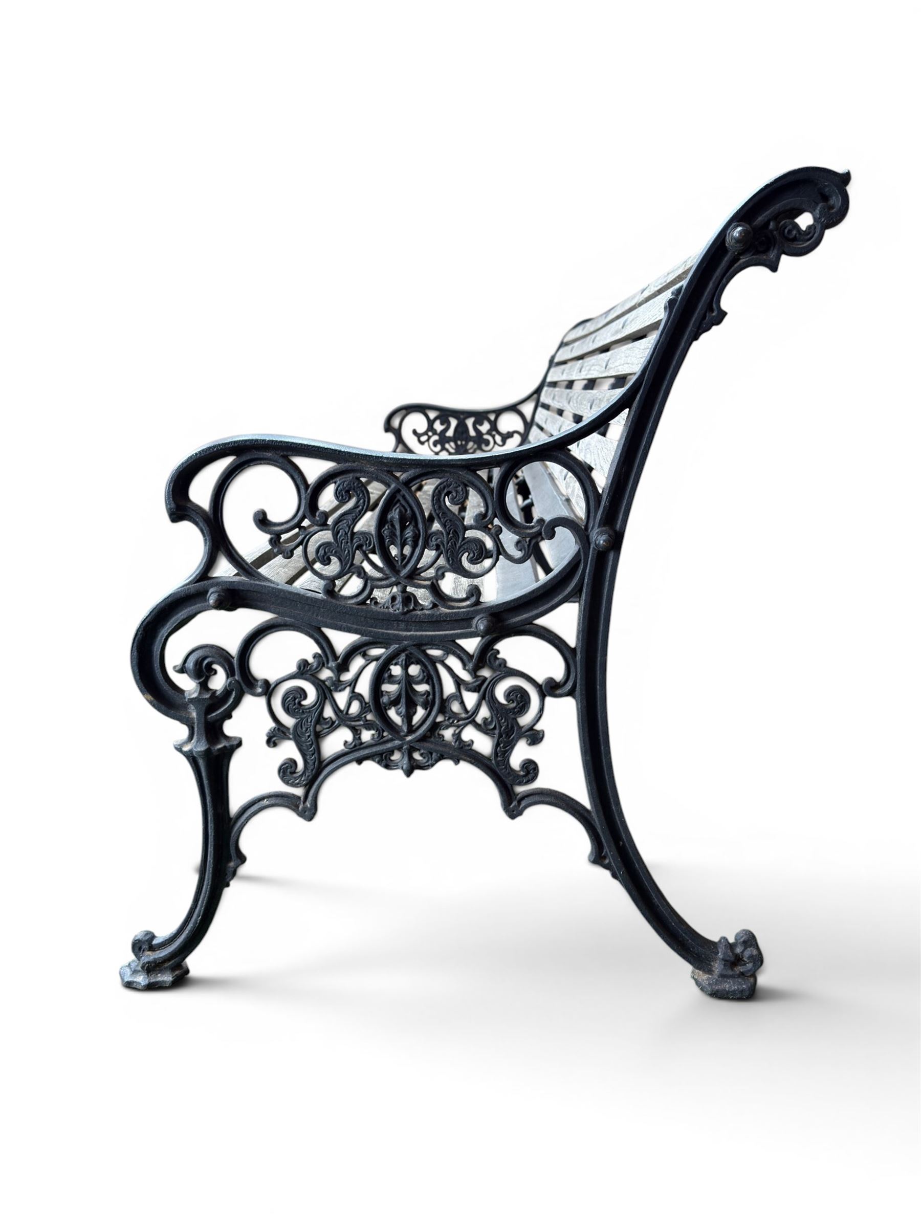 Victorian Andrew McLaren pattern cast iron bench, the ornate ends with detailed scrollwork, joined together with a cast iron seat and backrest frame supporting gently weathered oak slats, Victorian diamond stamp mark