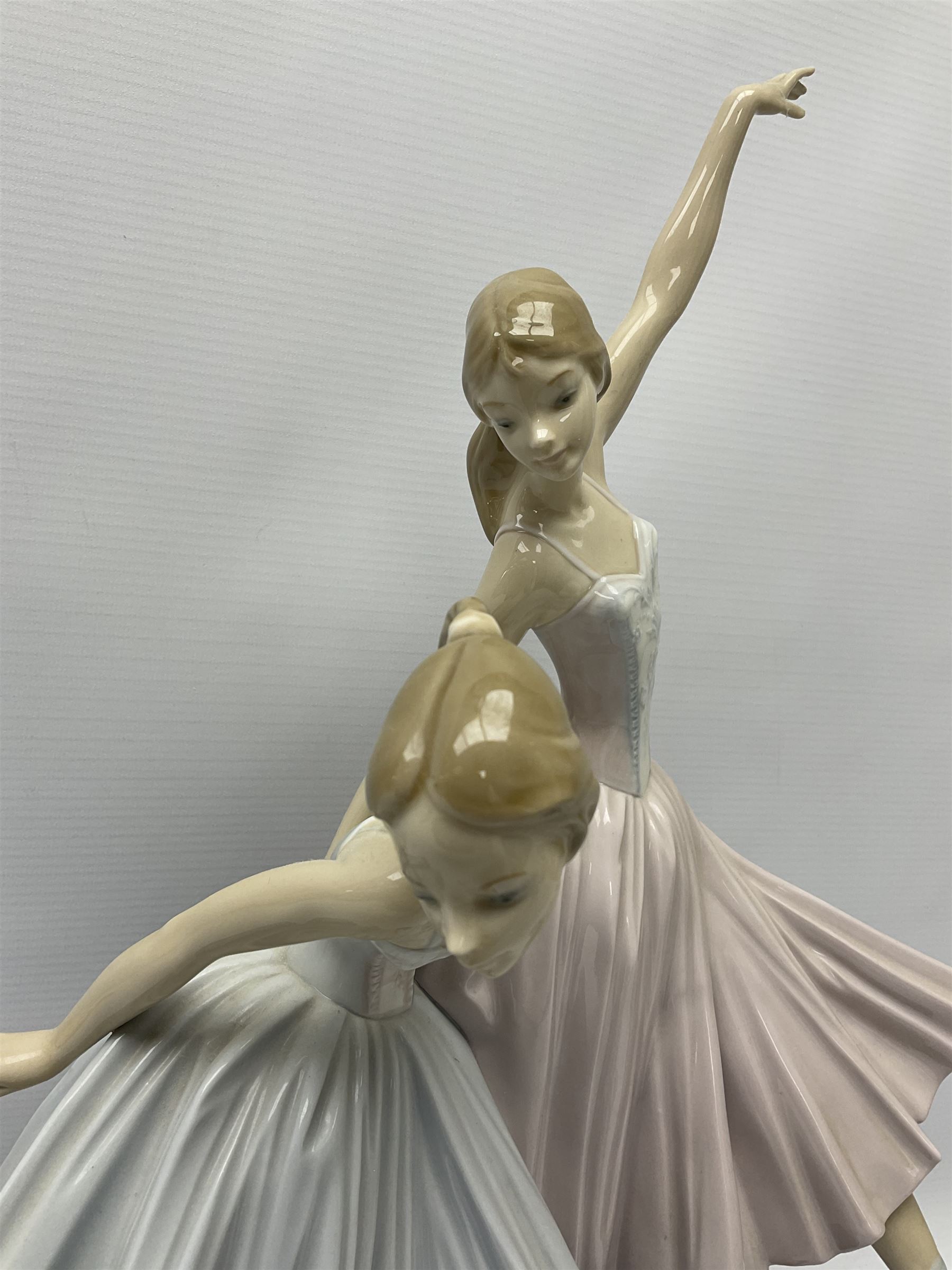 Lladro figure group, 'Merry Ballet', modelled as two ballerinas in dancing pose, raised on a turned socle base, no. 5035, printed marks beneath, H49cm