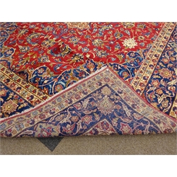  Large Persian Kashan rug carpet, large central rosette medallion on red ground field surrounded scrolling foliate, shaped spandrels with flower head motifs, repeating five banded border, 570cm x 330cm  