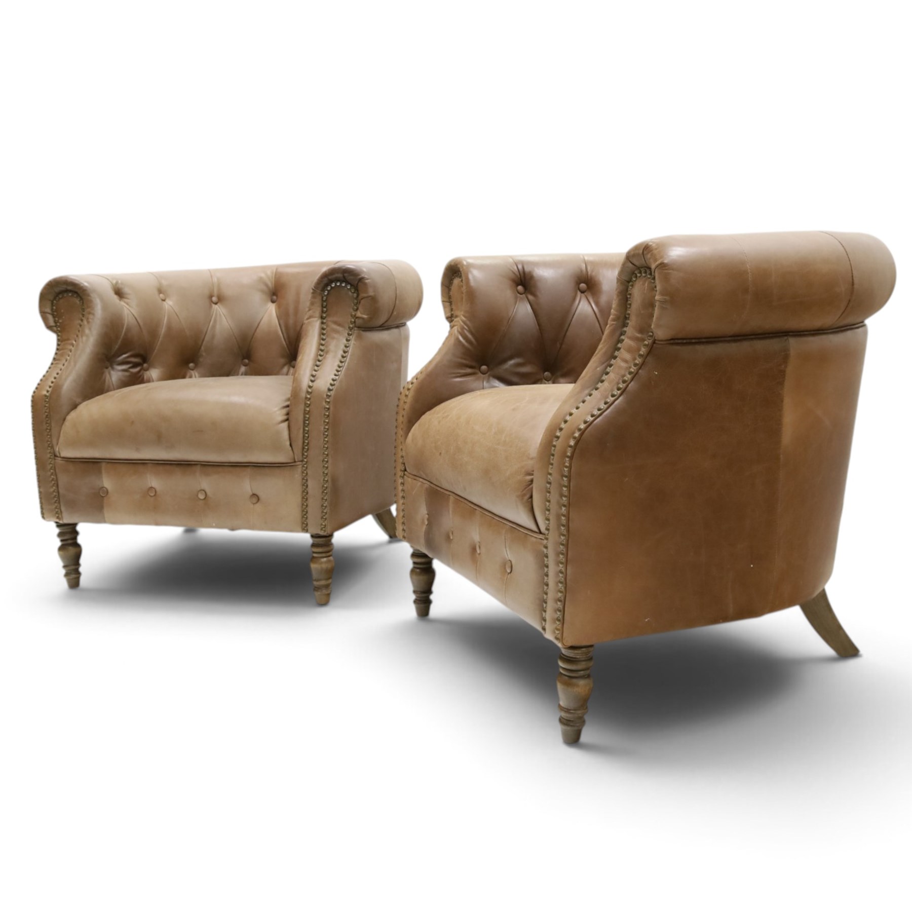 Alexander and James - pair of 'Jude' tub armchairs, traditional tub shape with buttoned back over deep seat, with studwork to the arm terminals, raised on turned front supports and splayed rear supports