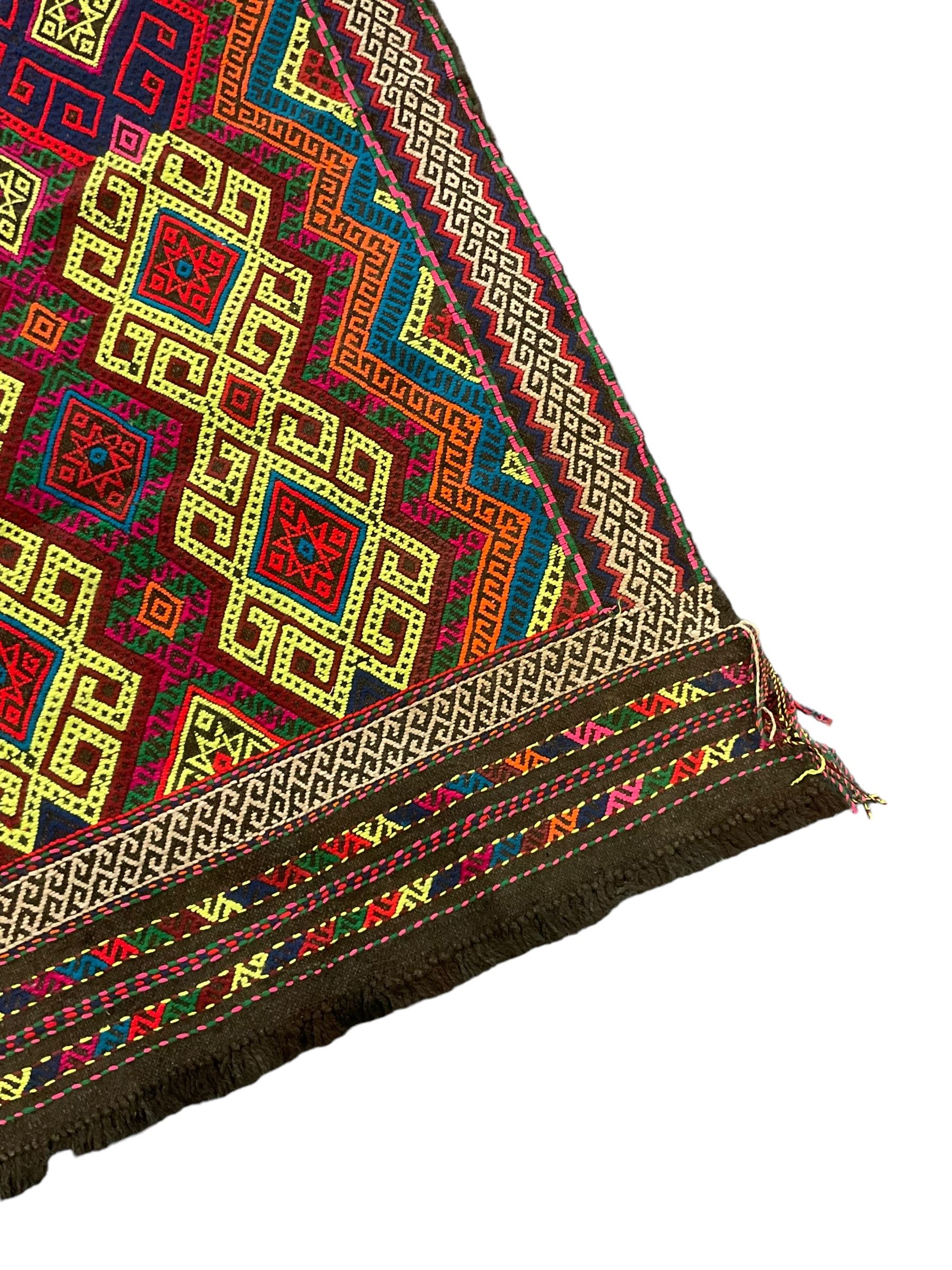 Flatweave geometric design rug, decorated with trailing hooked medallions within zig-zag bands, bright multi-coloured ground 