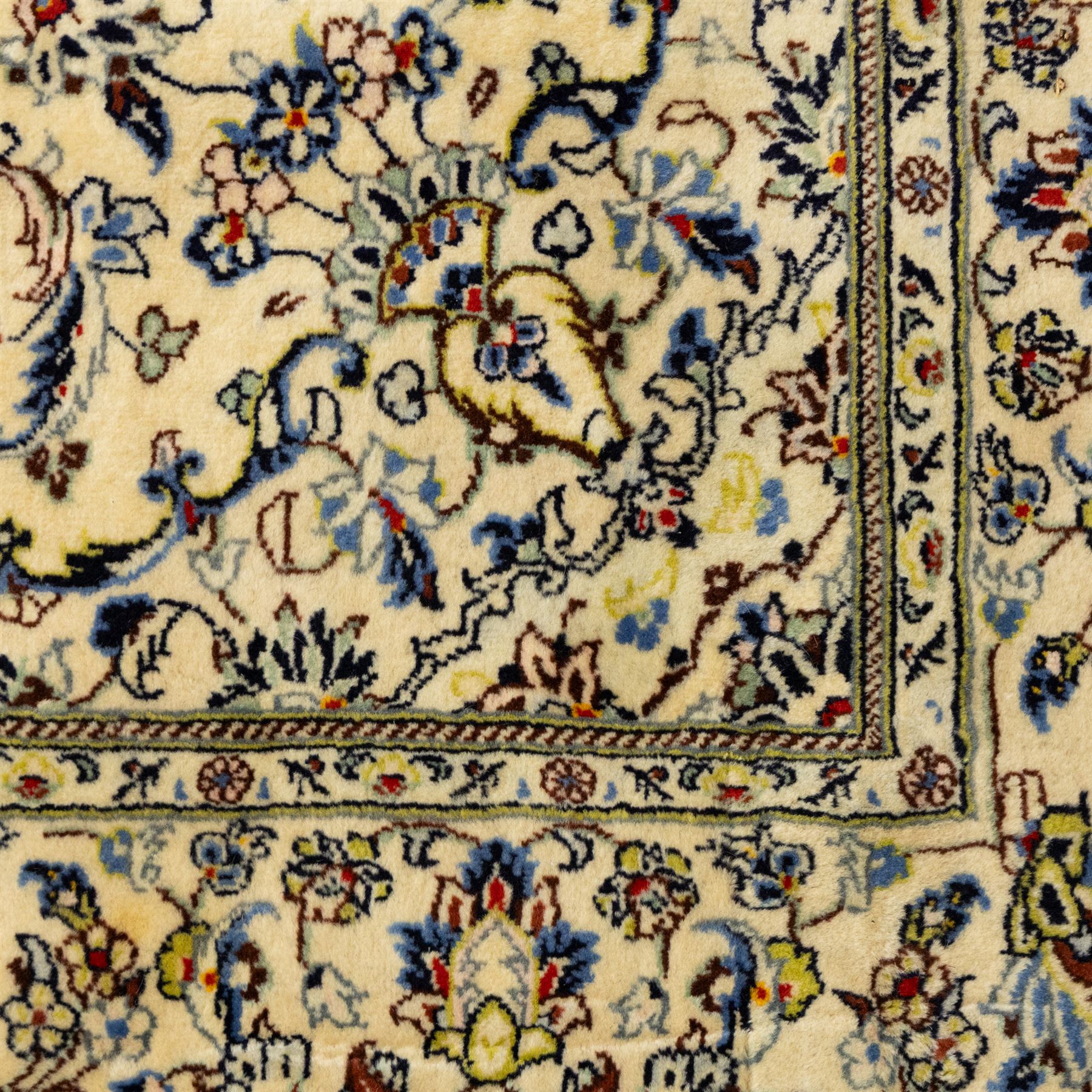 Central Persian Kashan hand-knotted rug, ivory ground, with a small central floral medallion and pendants, the field finely decorated with blue, cream and soft red scrolling vines, flowerheads and palmettes, within an ivory floral border and narrow guard stripes, with cotton fringes