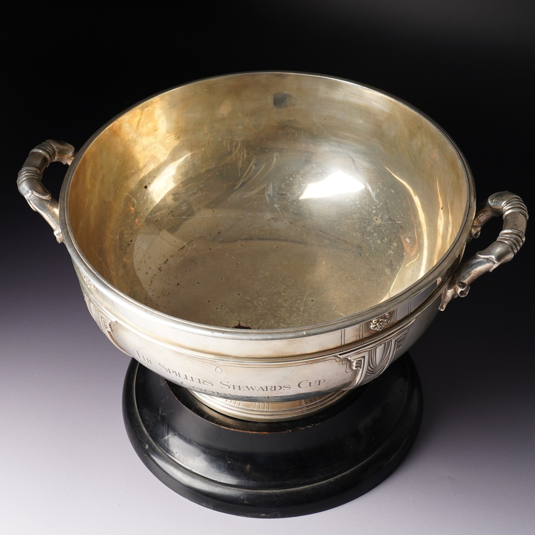 'The Spillers Stewards Cup, Goodwood 1973 Alphadamus' - Silver two handled rose bowl with lappet design on a short pedestal foot and ebonised plinth D28cm London 1958 Maker Edward Barnard & Sons Ltd
NB Alphadamus won the Stewards Cup in 1973 and provided Sir Michael Stoute with his first major career success.  
