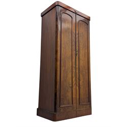 Victorian figured walnut single wardrobe, the moulded cornice with a central diamond motif over a pair of arched panelled doors with striking book-matched veneers, enclosing a fitted interior with hanging rail and hooks, on a plinth base