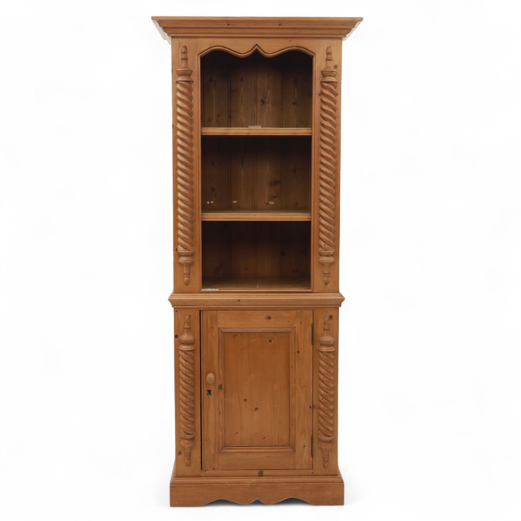 Contemporary stripped pine bookcase cabinet, the upper section with arched frieze and open shelving flanked by barley twist columns, over a single door cupboard base with matching twist supports and fielded panel door