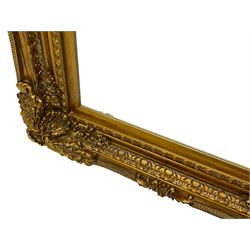 Gilt framed mirror, the frame decorated with cartouche and foliate corners with extending flower heads, inverted sea scrolls from the middle and egg and dart slip, bevelled plate 120cm x 89cm 