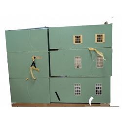 Two modern three storey dolls houses, each painted green with decorated interiors, both upon a single white wooden base, together with a large collection of dolls house furniture, accessories and figures 