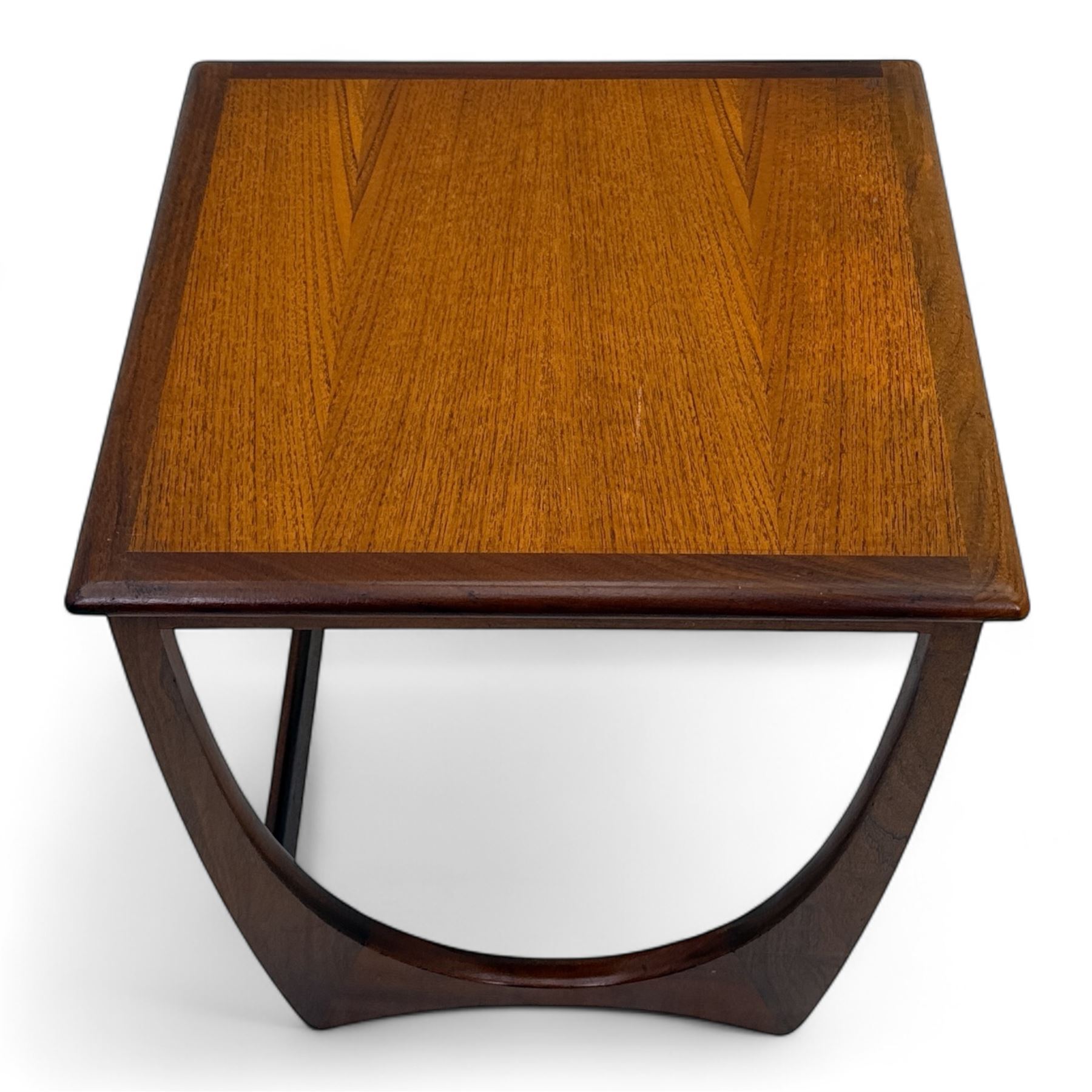 G-Plan - 'Astro' mid-century nest of three teak occasional tables, each with a square top with outer banding, on U-shaped end supports united by a stretcher