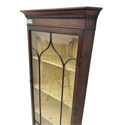 Early 20th century Georgian design mahogany wall-mounted corner display cabinet, projecting cornice with dentil frieze over astragal glazed door enclosing three fabric-lined shelves