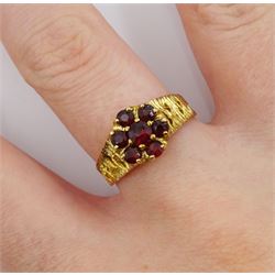 9ct gold garnet flower head cluster ring, with textured and pierced shoulders by Slade & Kempton, London 1978